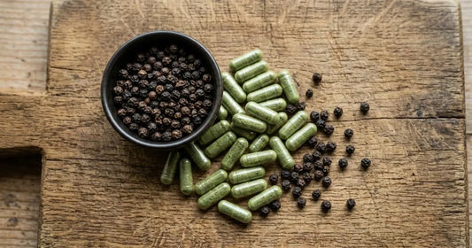 Organic Irish moss capsules with black pepper on a natural wood surface